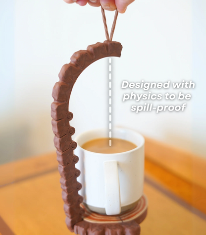 Chocolate-like spout design over a cup of coffee with text 'Designed with physics to be spill-proof'.